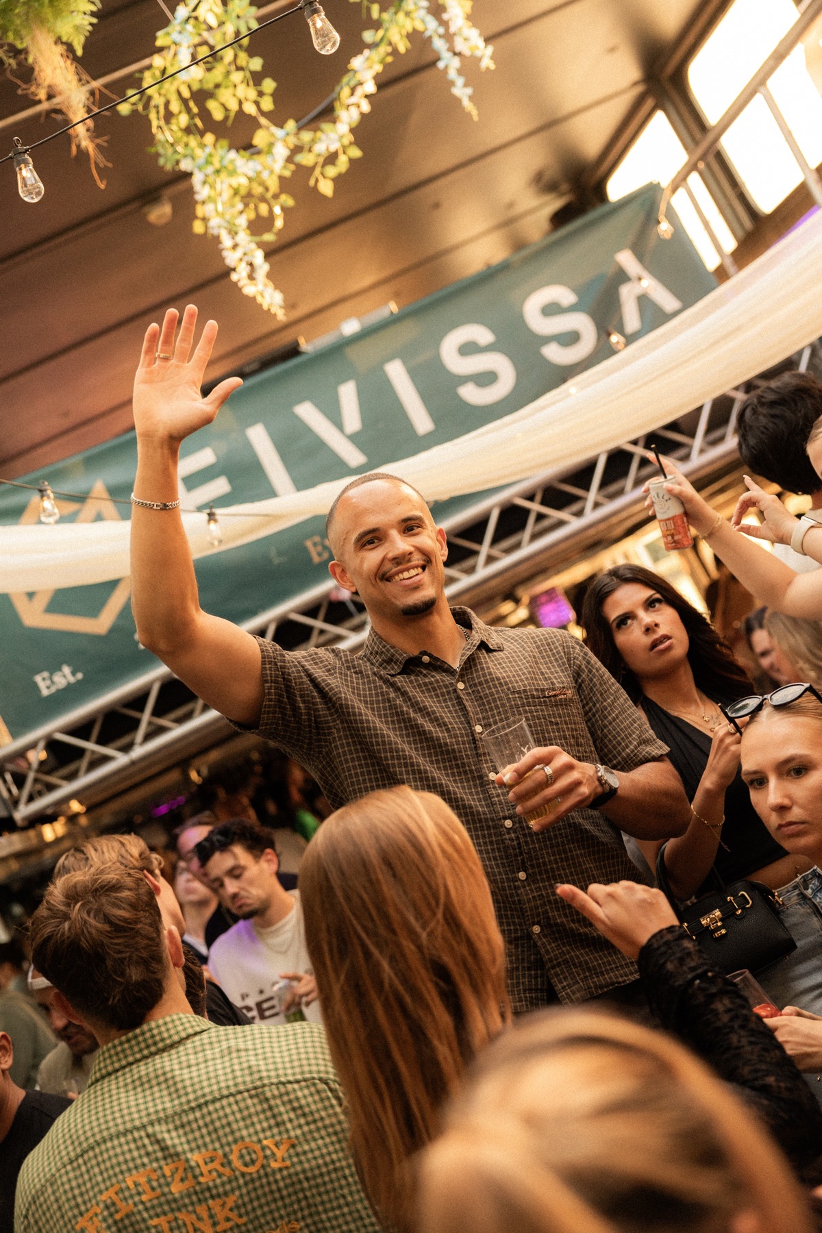 A guest raising his hand among the Sunset Cruise crowd